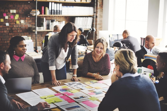 Une équipe est réunie autour d'un bureau dans une entreprise pour un atelier de design collaboratif