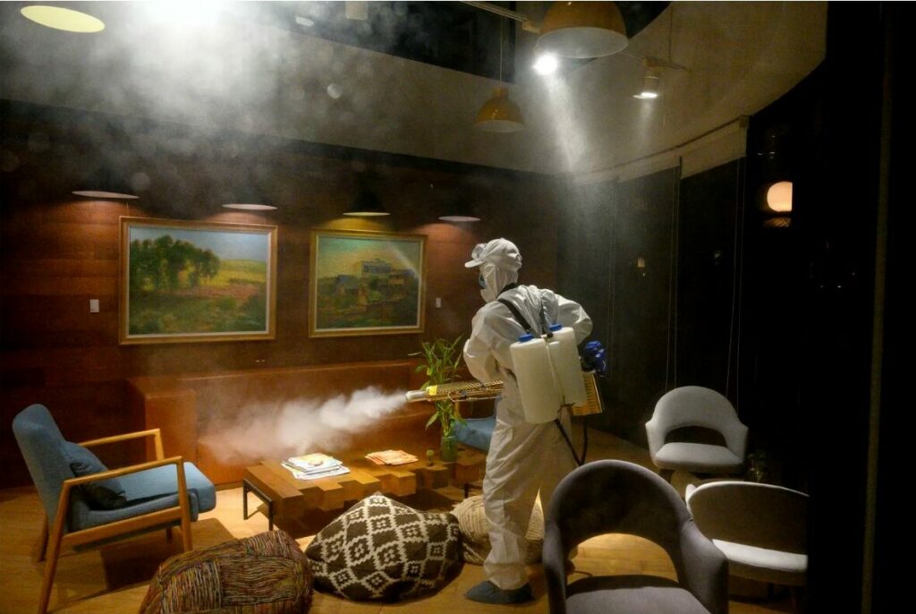 Un employé en combinaison Covid désinfecte un environnement de travail à Shanghai. Photo AFP Noel Celis